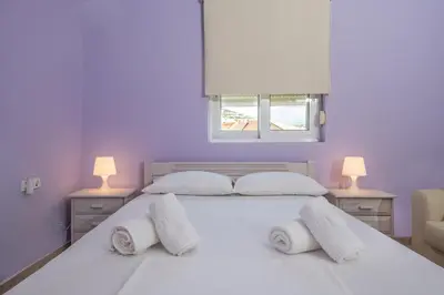 a bedroom with a white bed with two lamps at Kaloudis Apartment in Kissamos