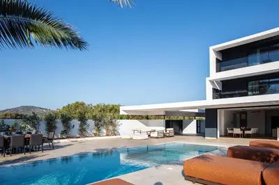 a house with a swimming pool next to a building at Nuera Villas in Chania Town
