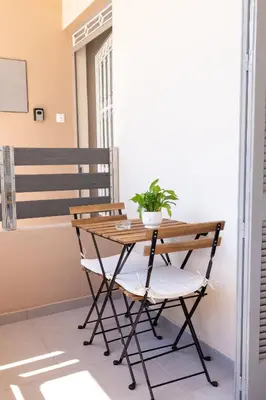 a wooden table and chair with a plant on a balcony at GOZA Cozy house in Chania Town