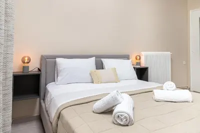 a bedroom with a large bed with white sheets and pillows at GOZA Cozy house in Chania Town