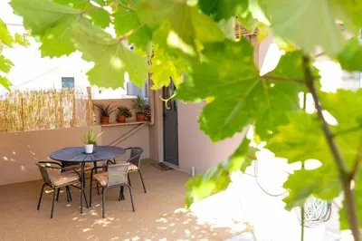 a patio with a table and chairs on a balcony at GOZA Cozy house in Chania Town