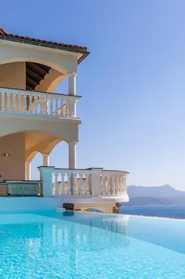 a villa with a swimming pool next to the ocean at Villa Sun Rock - Ravdoucha in Kolymvari
