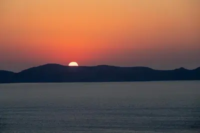 a sunset over the ocean with mountains in the background at Villa Sun Rock - Ravdoucha in Kolymvari