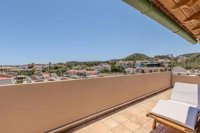 a balcony with a chair and a view of the city at Platanias Memories Apartment in Plataniás