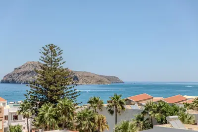 a view of the beach and palm trees and the ocean at Platanias Memories Apartment in Plataniás
