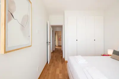 a white bedroom with a bed and a hallway at Kalyves Coastal Retreat in Chania Town