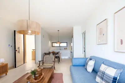 a living room with a blue couch and a table at Kalyves Coastal Retreat in Chania Town