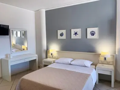 a bedroom with a bed with two night stands and a mirror at Platanias Memories Studio 5 in Plataniás