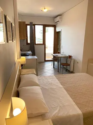a room with a bed and a kitchen with a table at Platanias Memories Studio 5 in Plataniás