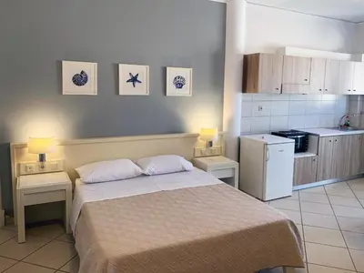 a bedroom with a bed and a small kitchen at Platanias Memories Studio 5 in Plataniás