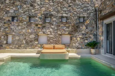 a room with a couch and a stone wall at Newly Renovated villa Artemis with Private Pool just 20min from Elafonissi in Livadia