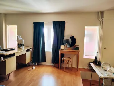 a room with blue curtains and a desk and a window at Lovely small apartment in Chania Town