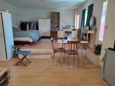 a living room with a table and chairs and a bedroom at Lovely small apartment in Chania Town