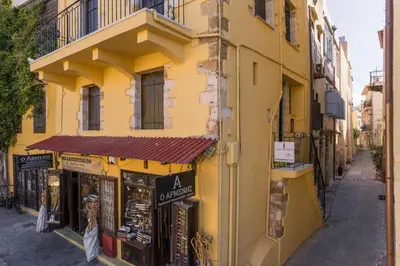 a yellow building with a store on a street at Full House in Chania Town