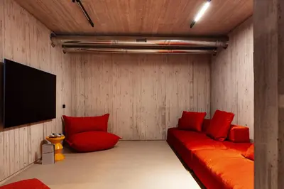 a room with a red couch and a flat screen tv at Beach Rock in Chania Town