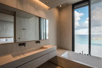 a bathroom with a tub and a large window at Beach Rock in Chania Town