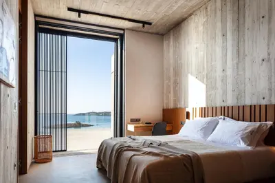 a bedroom with a large bed and a large window at Beach Rock in Chania Town