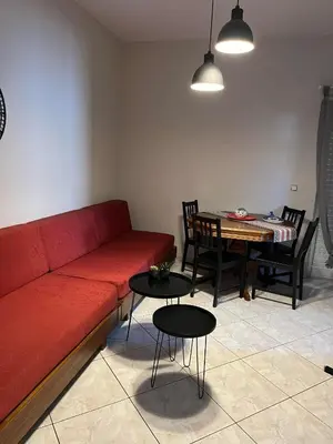 a living room with a red couch and a table at Vaso's comfort apartment 1 in Chania Town
