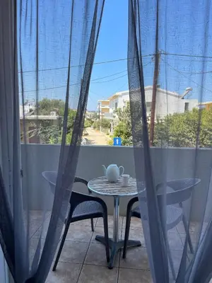 a table and chairs on a balcony with a window at Vaso's comfort apartment 1 in Chania Town