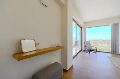 a living room with a mirror and a chair at Serenity in Stérnai