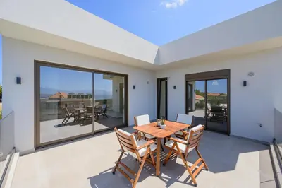 a dining room with a table and chairs on a patio at Serenity in Stérnai