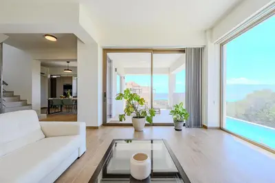 a living room with a white couch and a glass table at Serenity in Stérnai