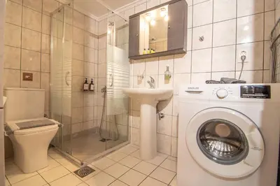a bathroom with a toilet a sink and a washing machine at Dream Apartments 3 in Palaiochóra