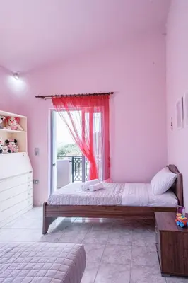 a bedroom with a bed and a window with a red curtain at Sofia's house 2 in Chania Town