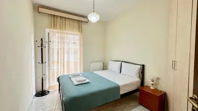 a bedroom with a bed with a green blanket and a window at Angie A2 close to the beach by 8essentially in Chania Town