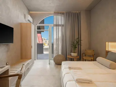 a hotel room with a large bed and a balcony at Hestia Boutique Rooms in Agia Marina Nea Kydonias