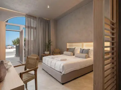 a bedroom with a large bed and a balcony at Hestia Boutique Rooms in Agia Marina Nea Kydonias
