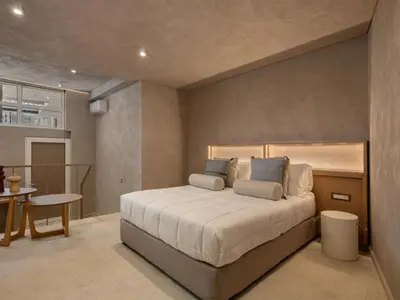 a bedroom with a bed and a table in it at Hestia Boutique Rooms in Agia Marina Nea Kydonias