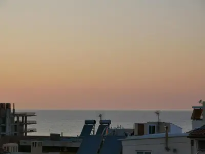 a view of the ocean from the roofs of buildings at Gio's Central Cosy Apartment with private balcony in Chania Town