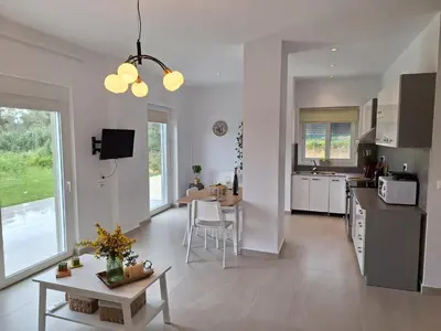 a kitchen and living room with a table and chairs at Iris&Phaedra in Ayiá
