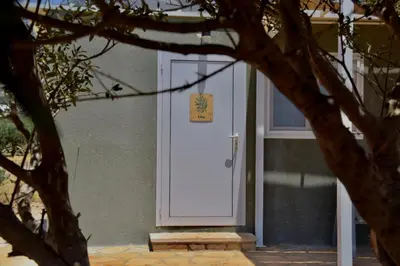 a white door of a building with a sign on it at Agros simple living in Frangokastello