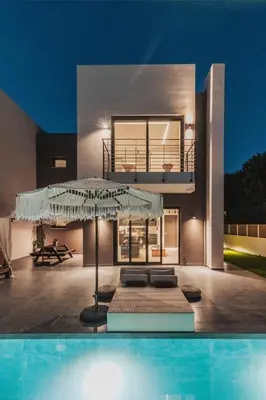 a villa with a swimming pool in front of a house at Nos Aqua Villas Chania in Pazinos