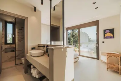 a bathroom with a sink and a mirror at Nos Aqua Villas Chania in Pazinos
