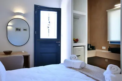 a bedroom with a blue door and a bed with towels at Casa Kallisti in Chania Town