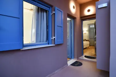 a room with blue windows and a bedroom at Casa Kâllisti Grande in Chania Town