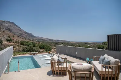 a patio with chairs and a swimming pool at Nature's Den in Frangokastello