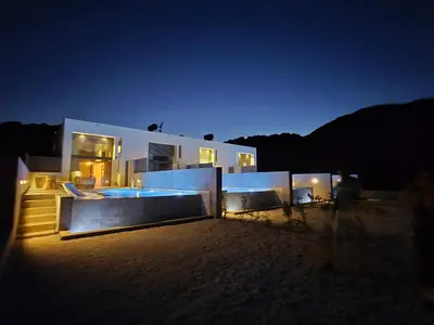 a large house with a swimming pool at night at Nature's Den in Frangokastello