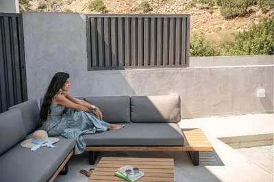 a woman sitting on a couch in a living room at Nature's Den in Frangokastello