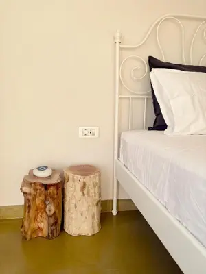 a bedroom with a bed and a log side table at Mekia's beach house in Livadia