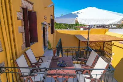 a table and chairs with an umbrella on a balcony at SternesVillage, Premium Balcony Suite in Stérnai