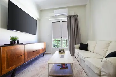 a living room with a couch and a flat screen tv at Sophia Apartment in Chania Town