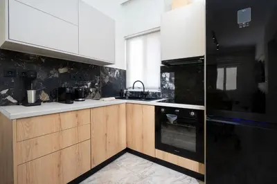 a kitchen with wooden cabinets and black and white appliances at Sophia Apartment in Chania Town