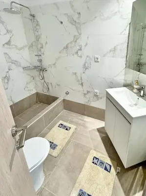 a white bathroom with a toilet and a sink at Christina & Suzan Apartment in Chania Town