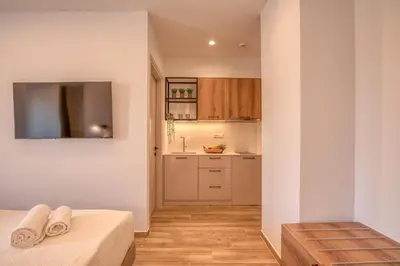 a room with a kitchen and a bed with towels at Kiwi Boutique Studios in Kissamos