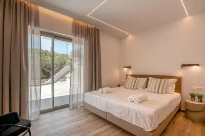 a bedroom with a large bed and a large window at Kiwi Boutique Studios in Kissamos