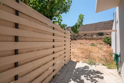 a wooden fence next to a driveway at Vissalo Studios in Kissamos